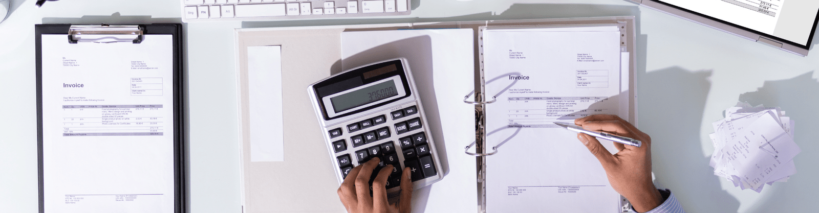 Business owner reviewing ERC eligibility documents with a laptop and calculator.