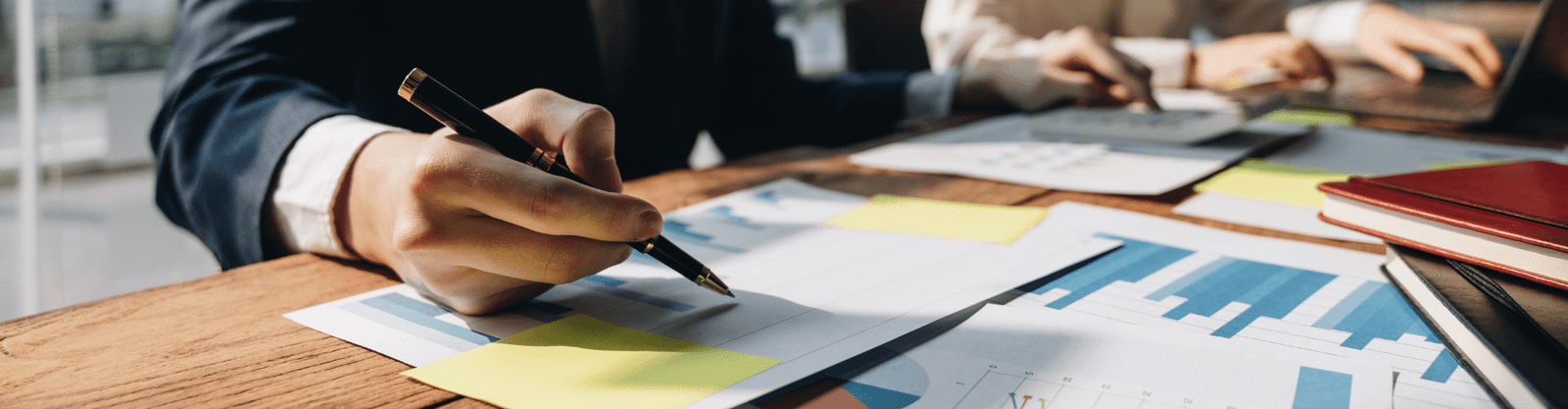 Business professionals analyzing financial charts and graphs at a desk, highlighting data-driven tax planning and strategic decision-making.
